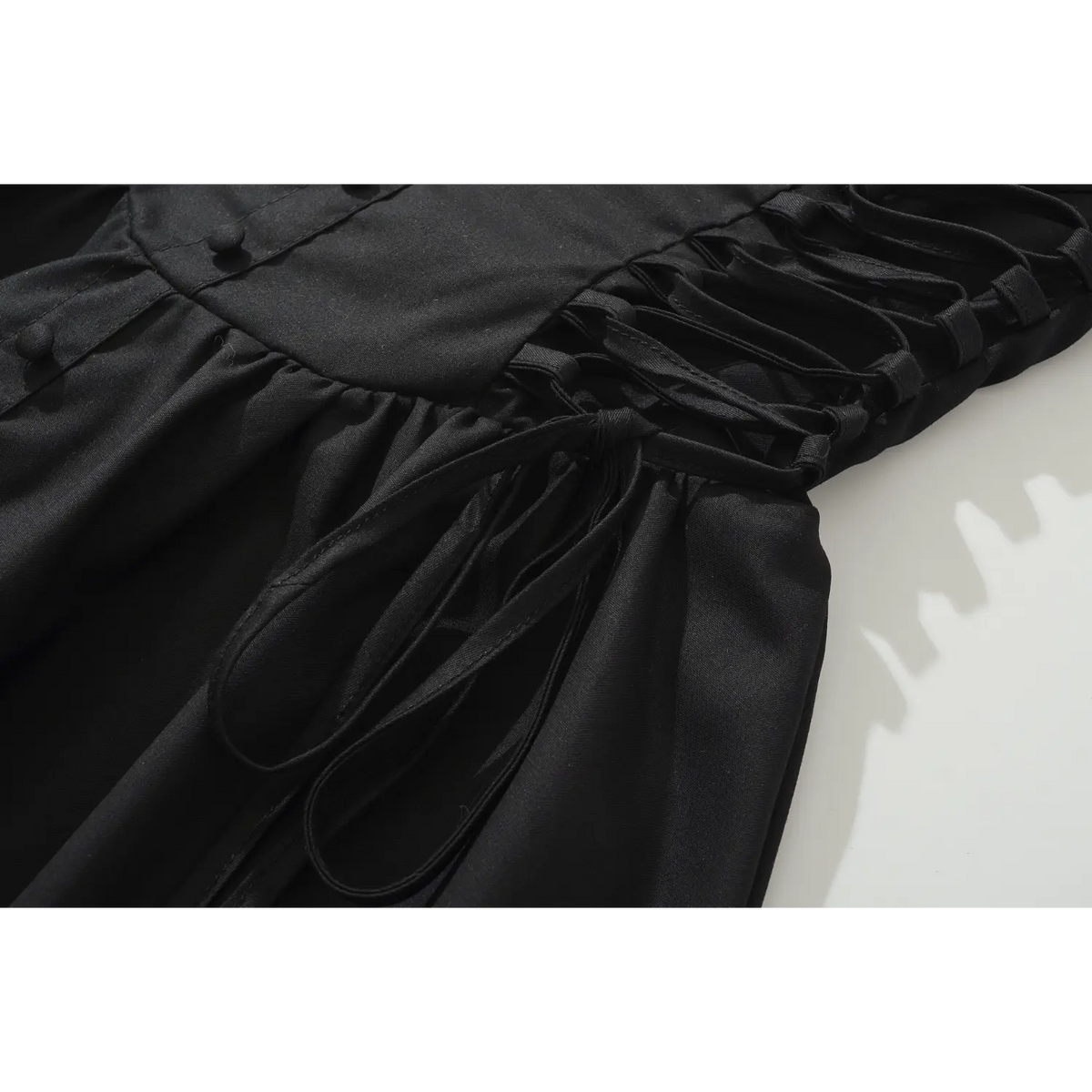 Close up of side lace-up tie details on black sleeveless mini dress