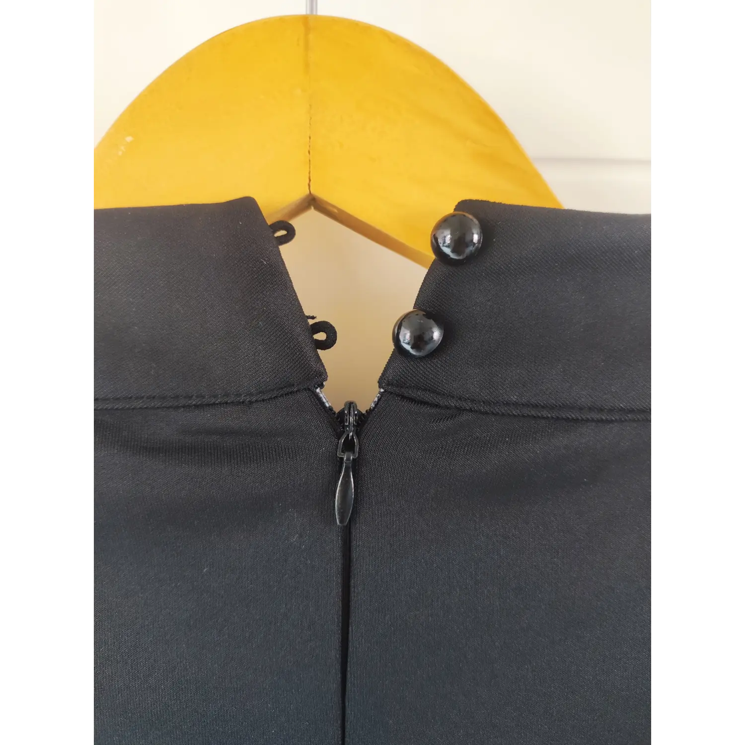 Close-up shot, stand collar black dress back neck, black bead buttons and invisible zipper detail