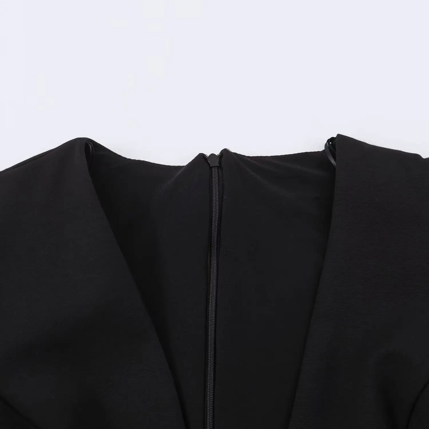 Close-up detail of deep V neck and invisible back zipper on black mini dress