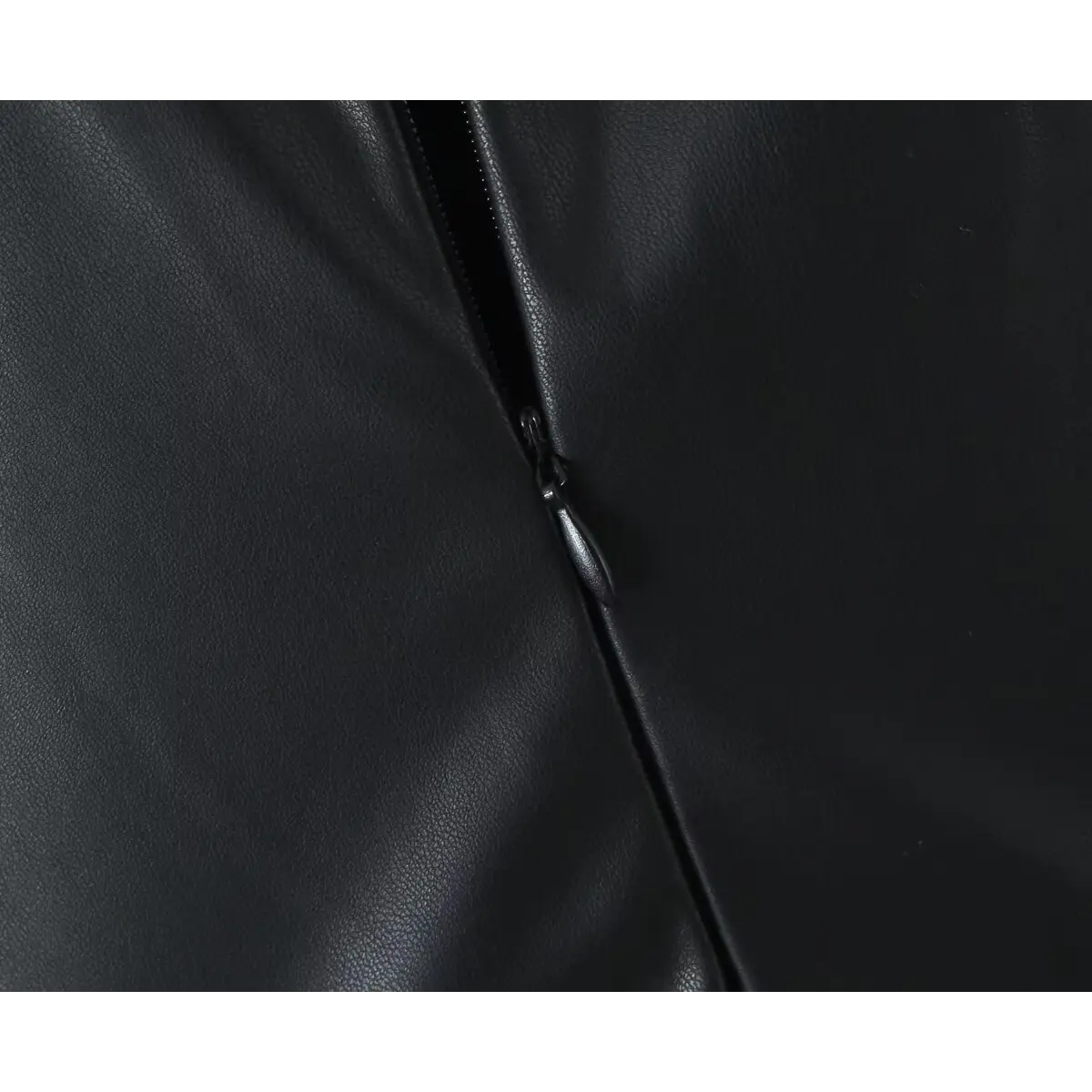 Close-up detail of the center-back metal zipper on a black faux-leather mini dress.