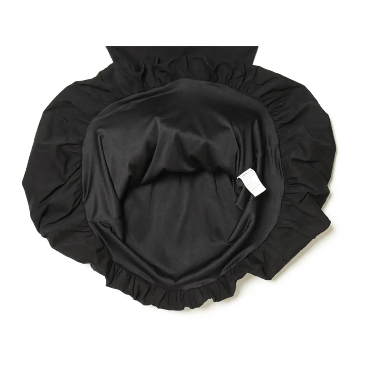  Interior view of black dress, displaying the gathered lining and attached care label