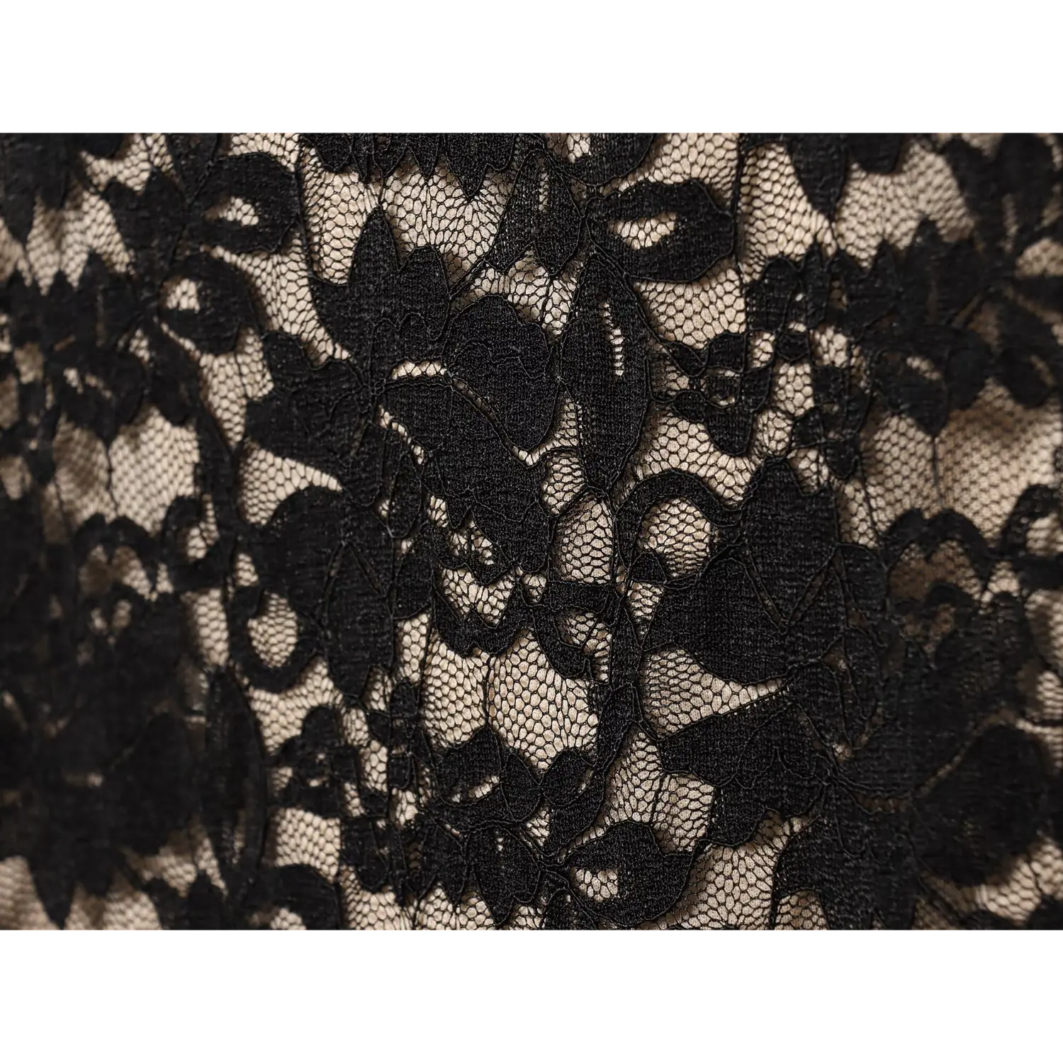 Macro close‑up black floral lace fabric texture over nude lining