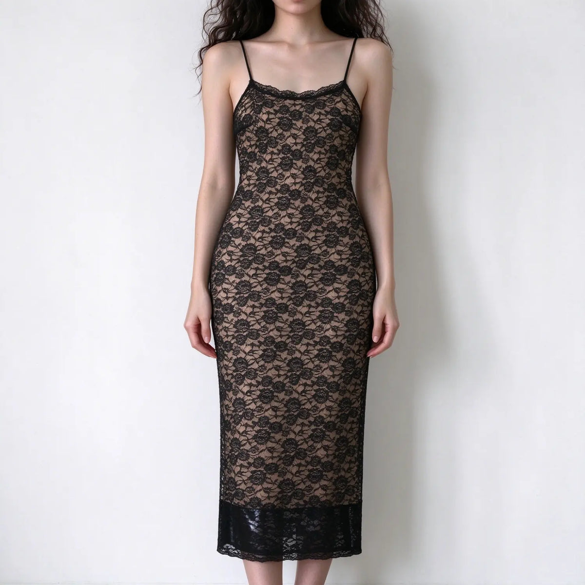 Model in black floral lace spaghetti strap maxi slip dress, bodycon fitted silhouette, sheer lace outer layer, full length maxi hem, white background