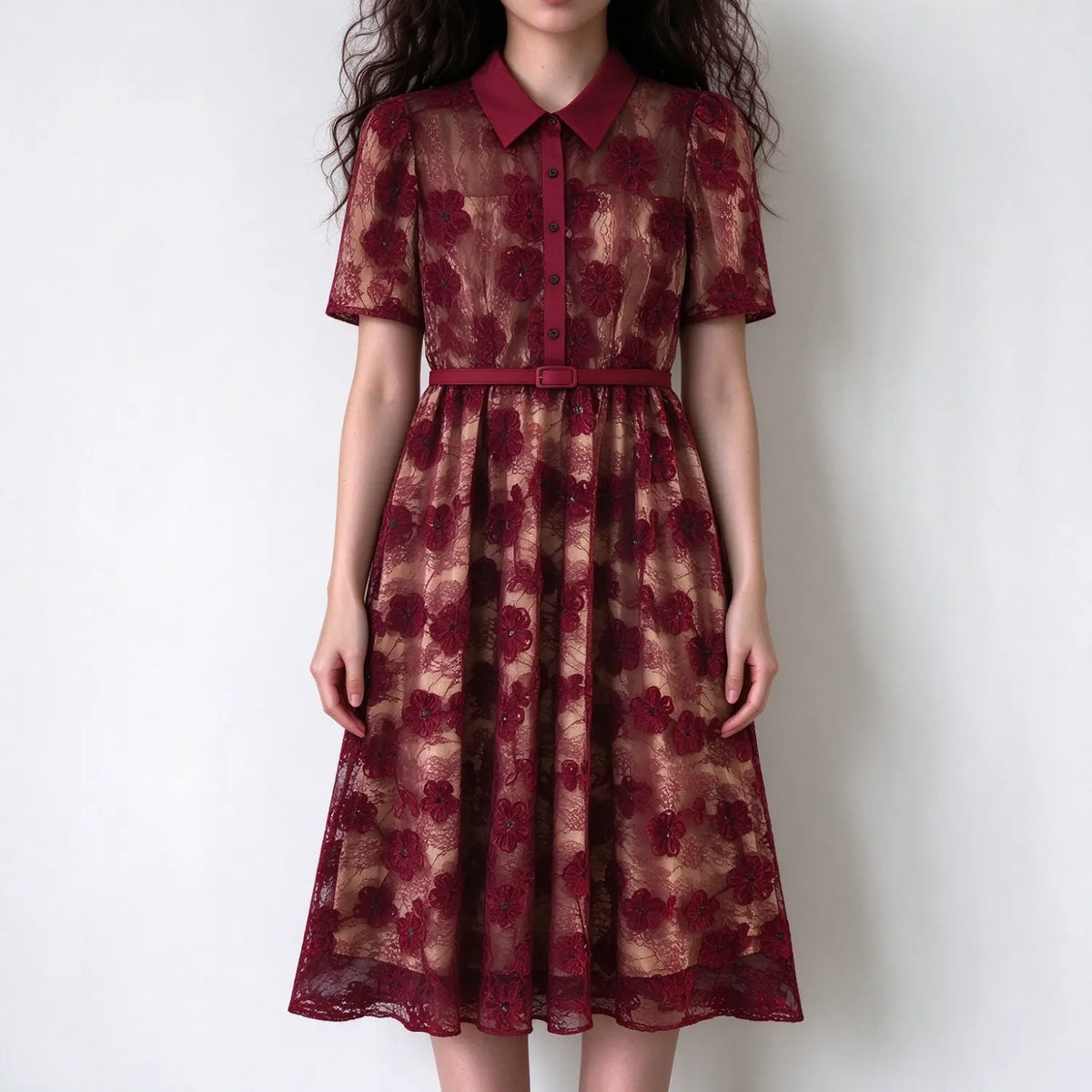 Model wearing burgundy 3D floral lace maxi dress, shirt collar, short puff sleeves, matching waist belt, A-line full maxi skirt, lace overlay, plain white background