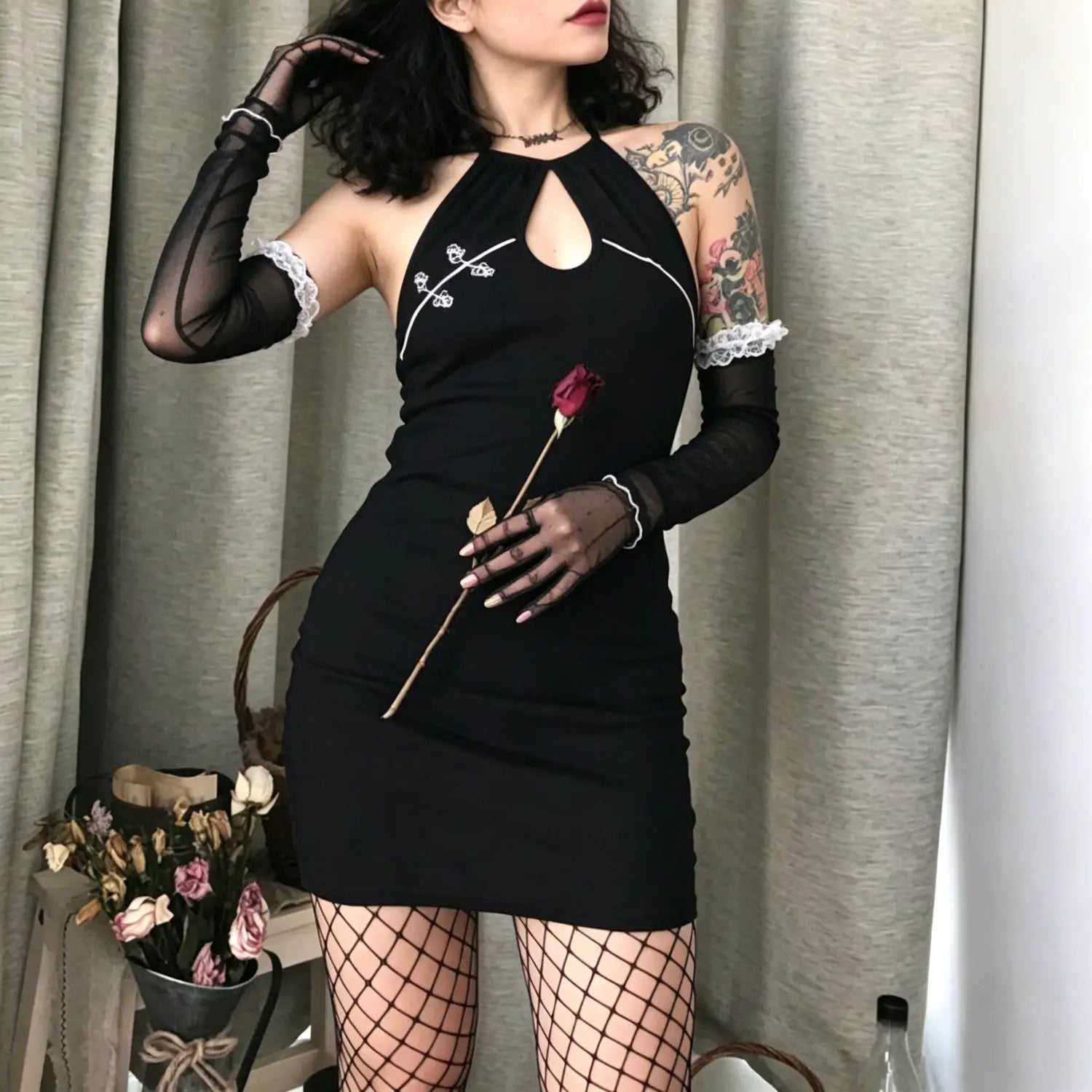 Studio model pose in black ribbed halter neck keyhole cutout embroidered bodycon mini dress