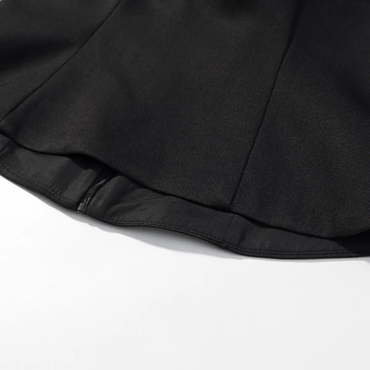 Bottom hem detail of black halter bustier top, showing the side zipper and lining