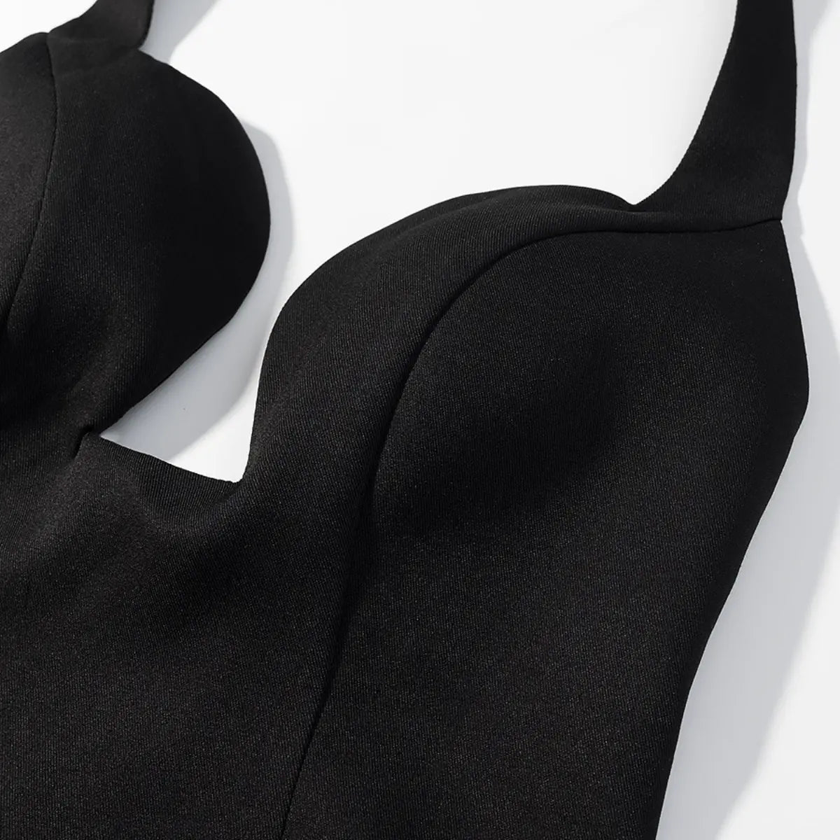 Bust detail of black halter bustier top, showing the structured cups and fabric texture