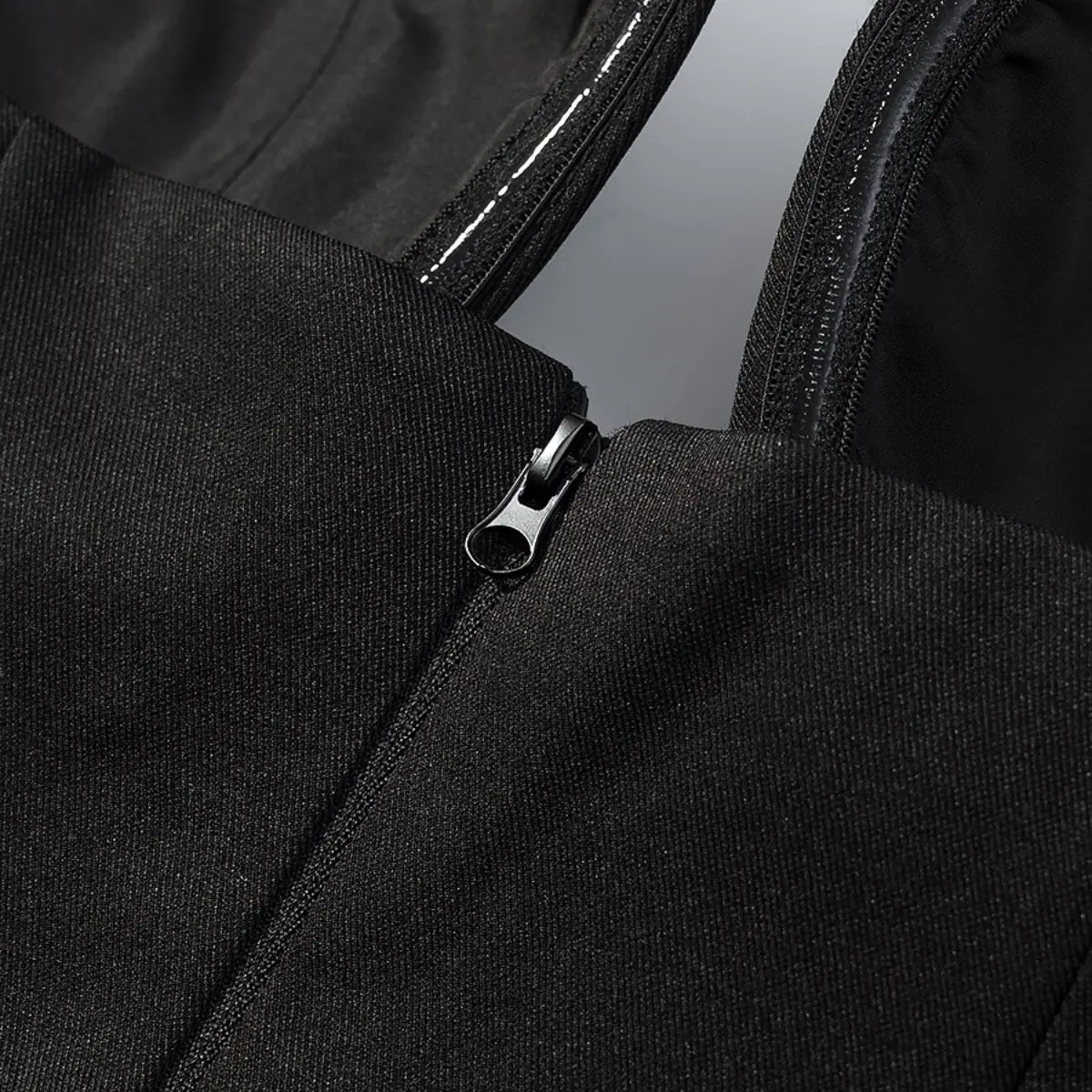 Close-up of the side zipper pull on the black halter bustier top
