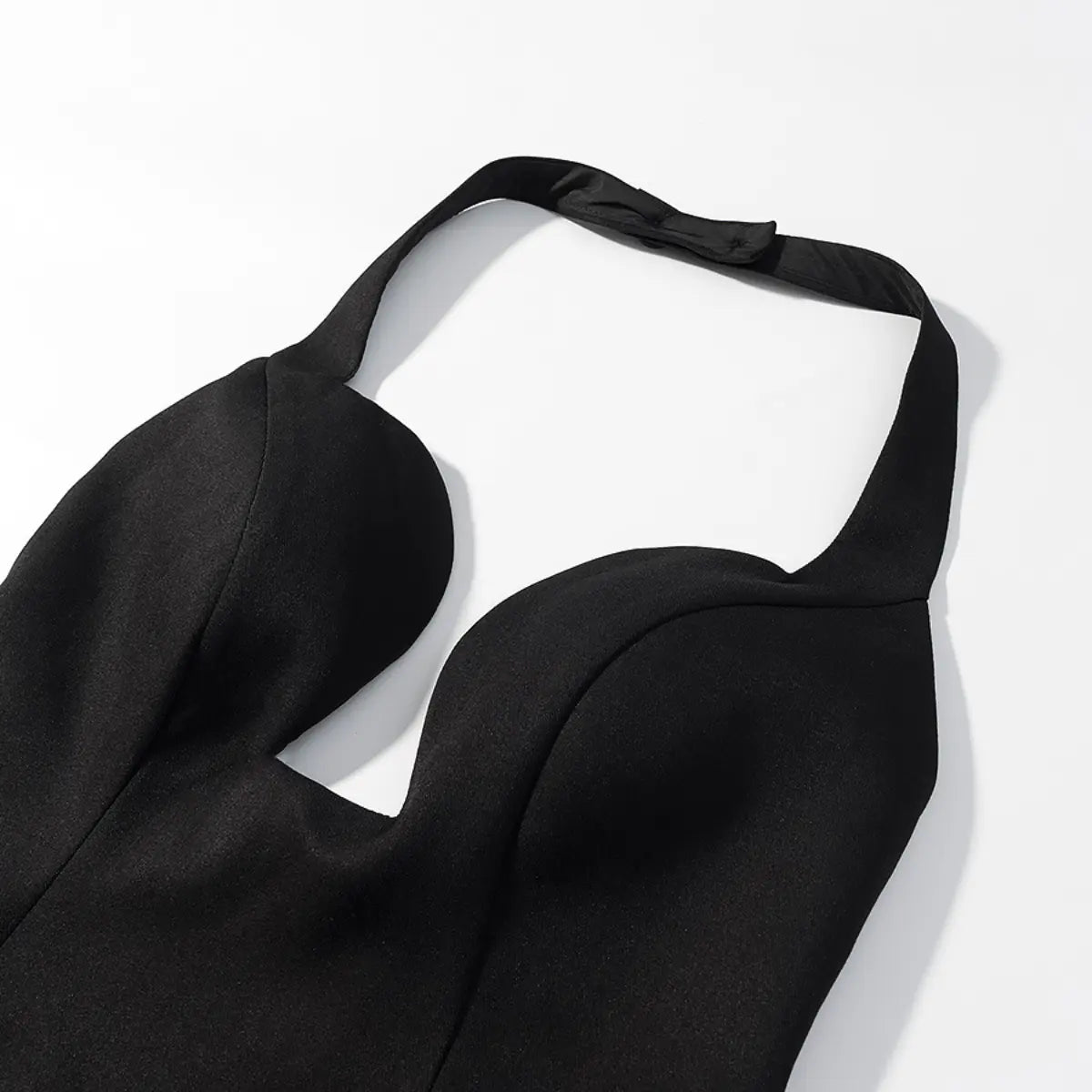Neckline detail of black halter bustier top, showing the plunging sweetheart cut and halter strap