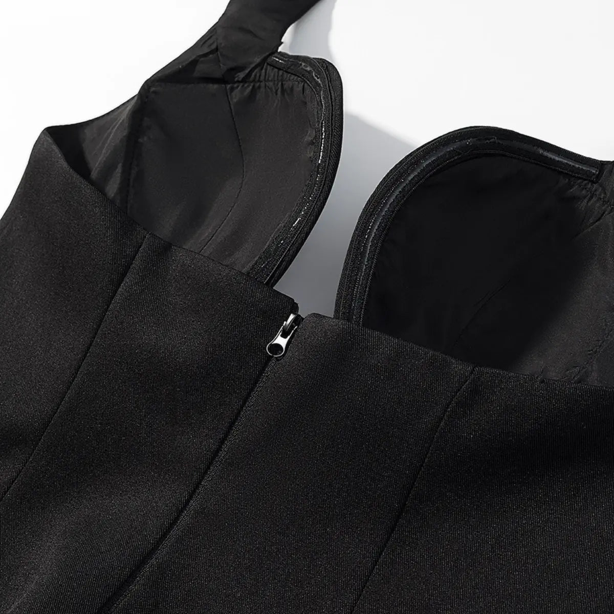 Side view of the zipper on the black halter bustier top, showing the boned cups and lining
