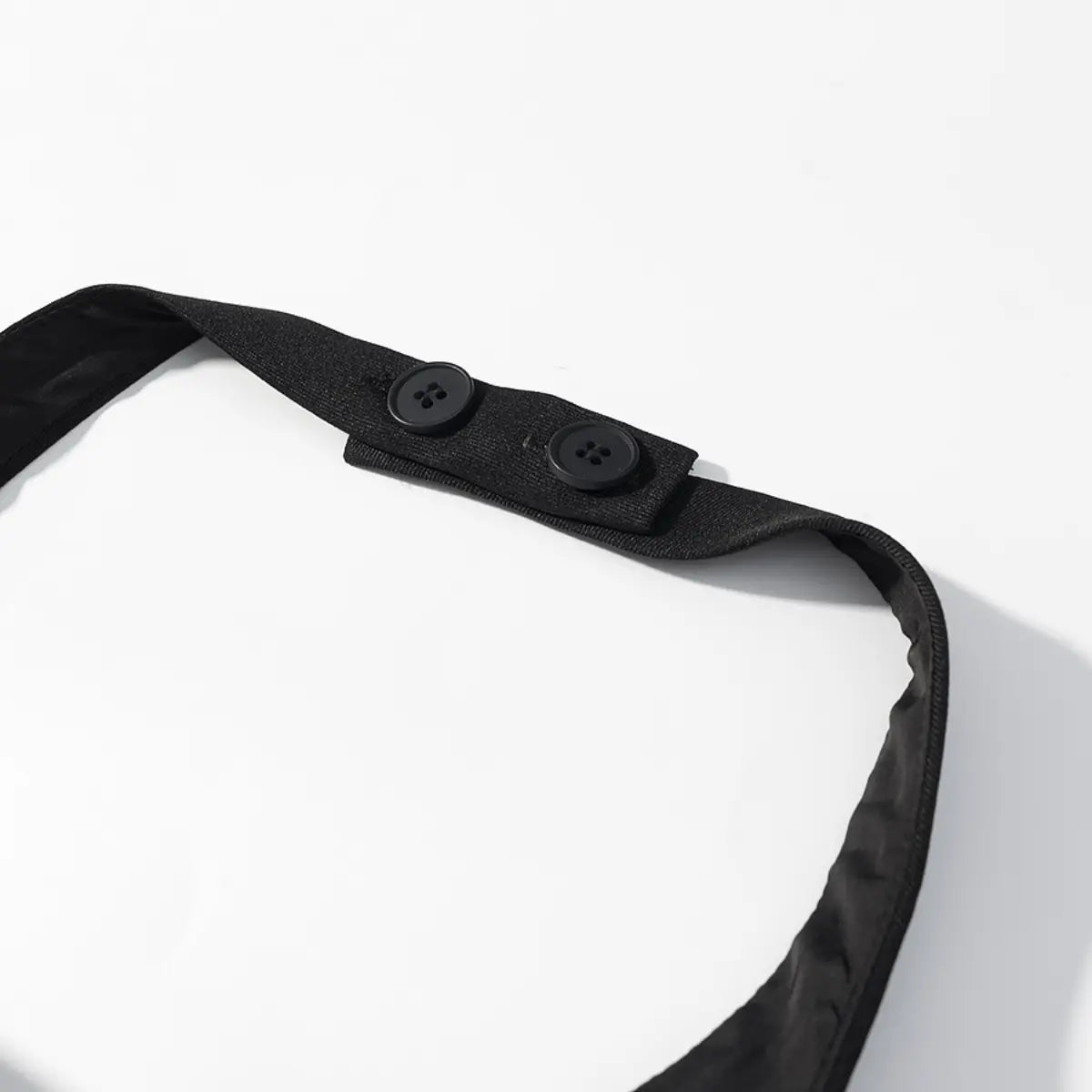 Close-up of the halter strap on the black bustier top, showing the two-button closure