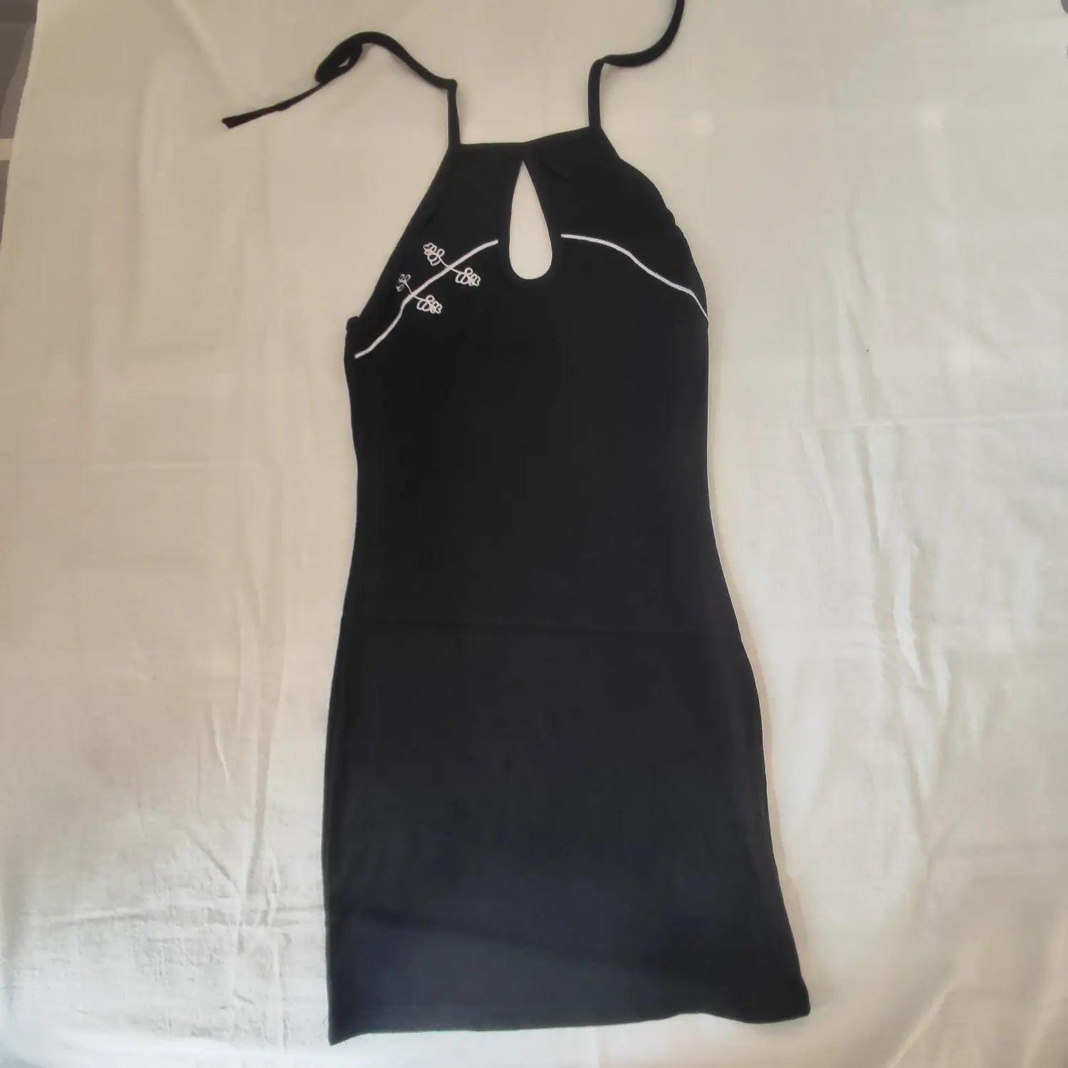 Flat lay full front view black halter tie neck mini dress with white floral embroidery detail
