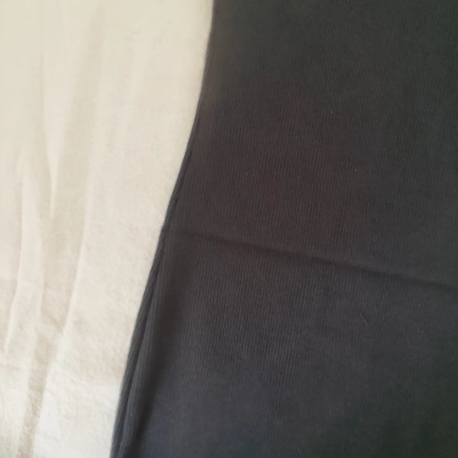 Extreme close‑up of black vertical ribbed knit fabric texture of halter bodycon mini dress