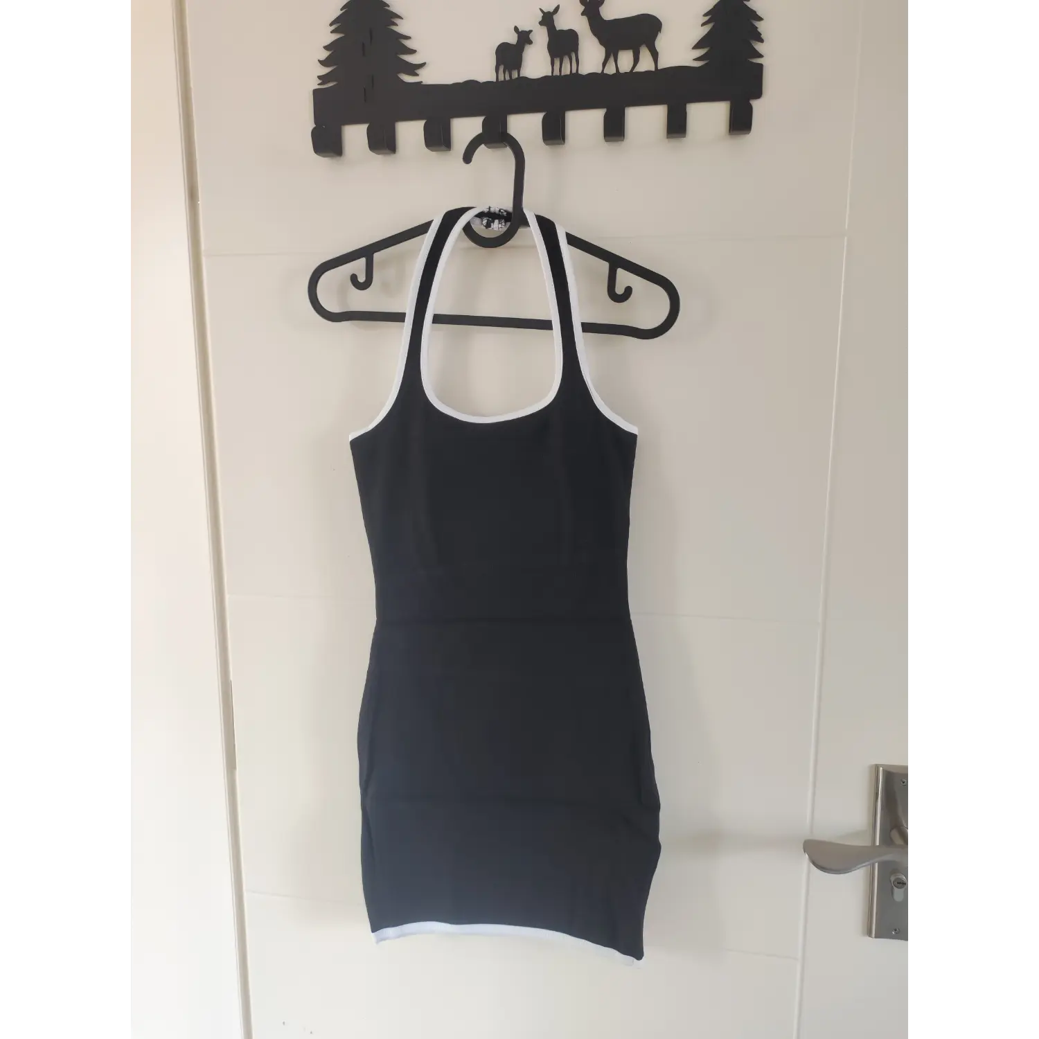 Hanger shot full front view black halter neck ribbed bodycon mini dress white edge trim