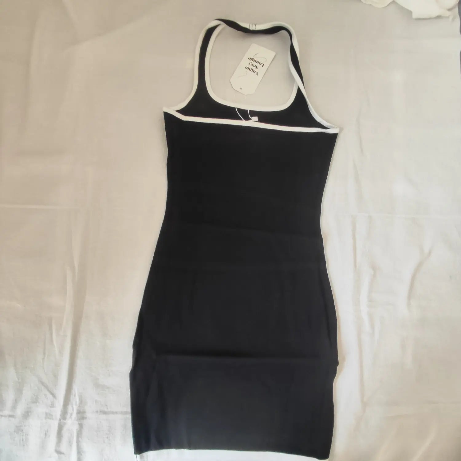 Flat lay back view black halter ribbed mini dress with hang tag, white contrast trim
