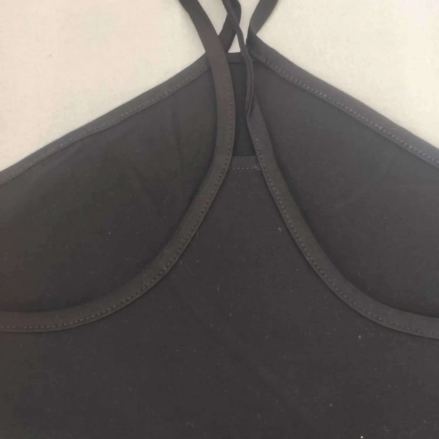 Close‑up inner halter strap and neckline seam construction black halter tank top