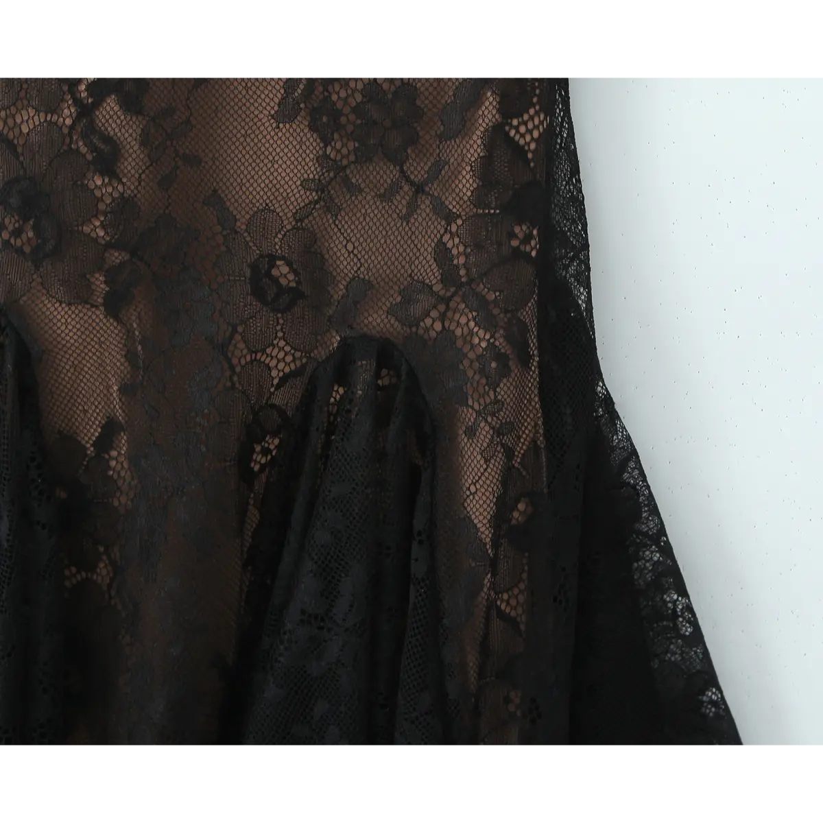 Close-up of the flared babydoll skirt with layered black floral lace