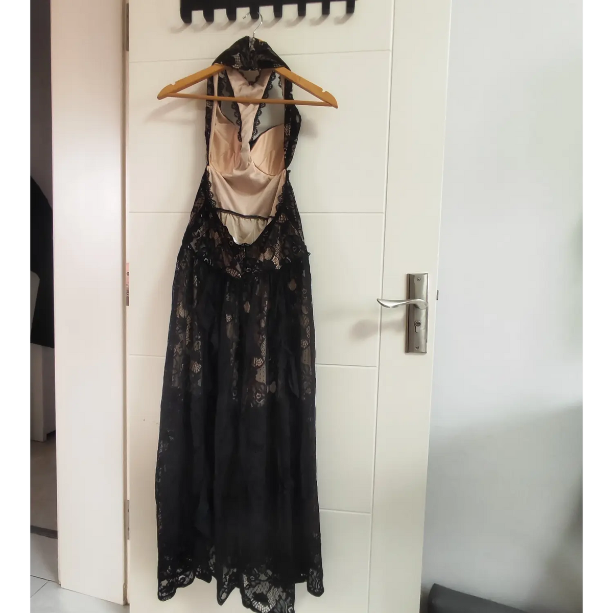 Back view of black lace halter maxi dress hanging on hanger