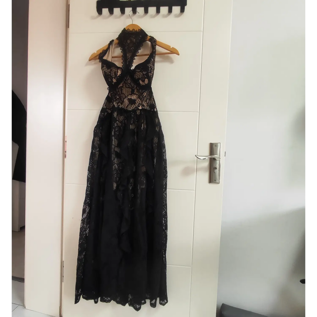 Black floral lace halter maxi dress hanging on wooden hanger front view