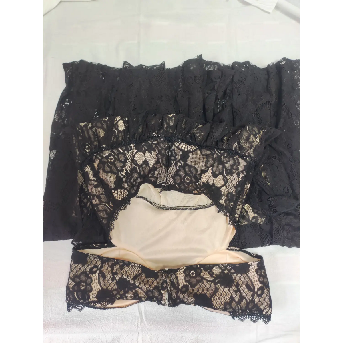 Flat lay view of black lace maxi dress showing back zipper and nude lining
