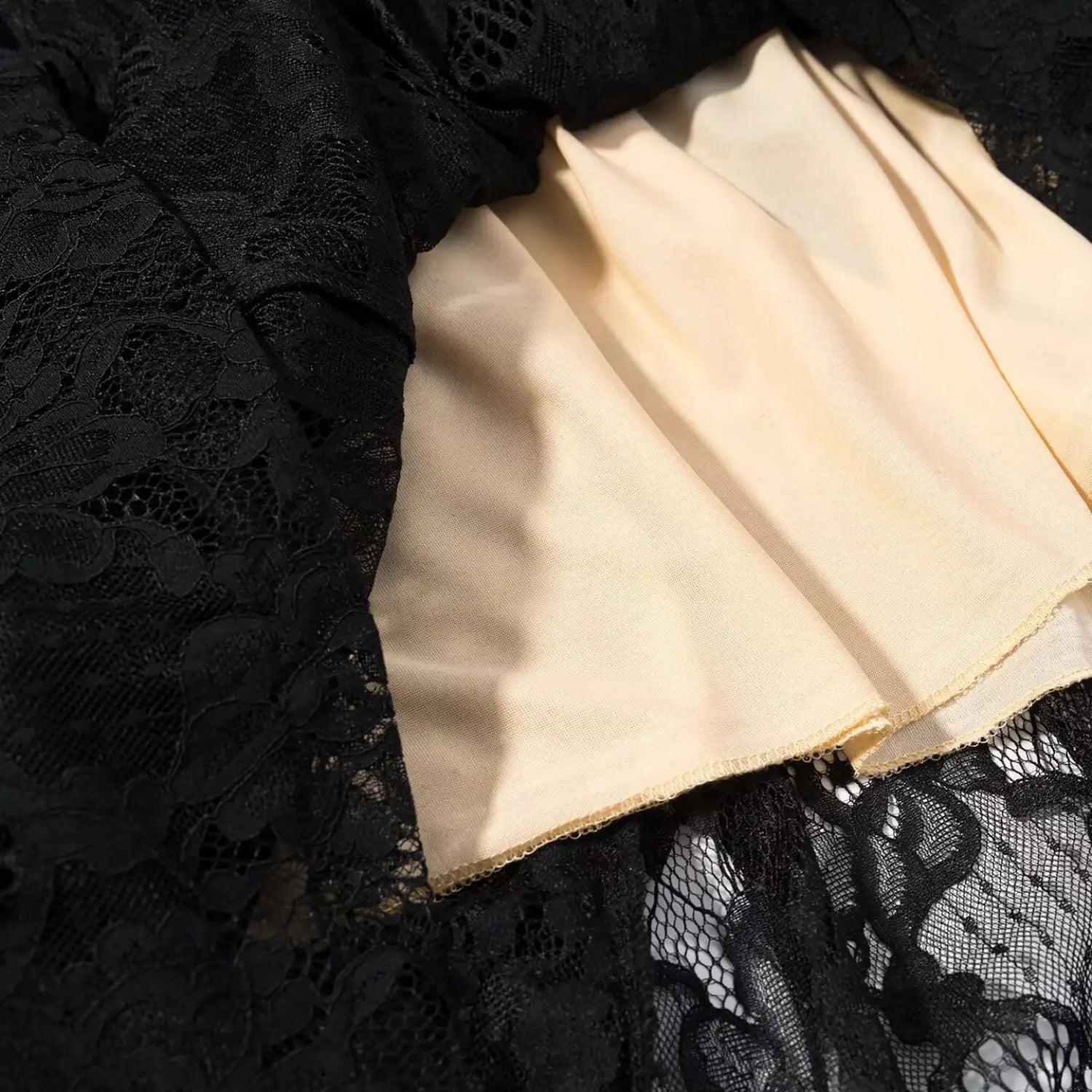 Black floral hollow lace maxi dress nude lining ruffle hem macro close-up, smooth matte full lining neat serging stitching double non-sheer hem craft shot
