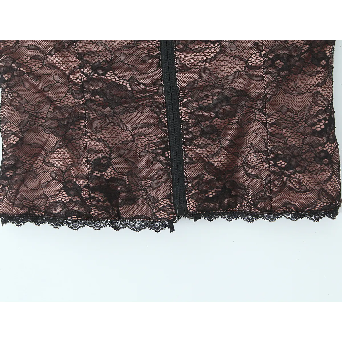 Close-up of the scalloped lace hem and central zipper on the black lace bustier top.