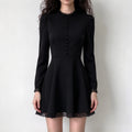 Model wearing black lace trim mock neck button flare mini dress, front view