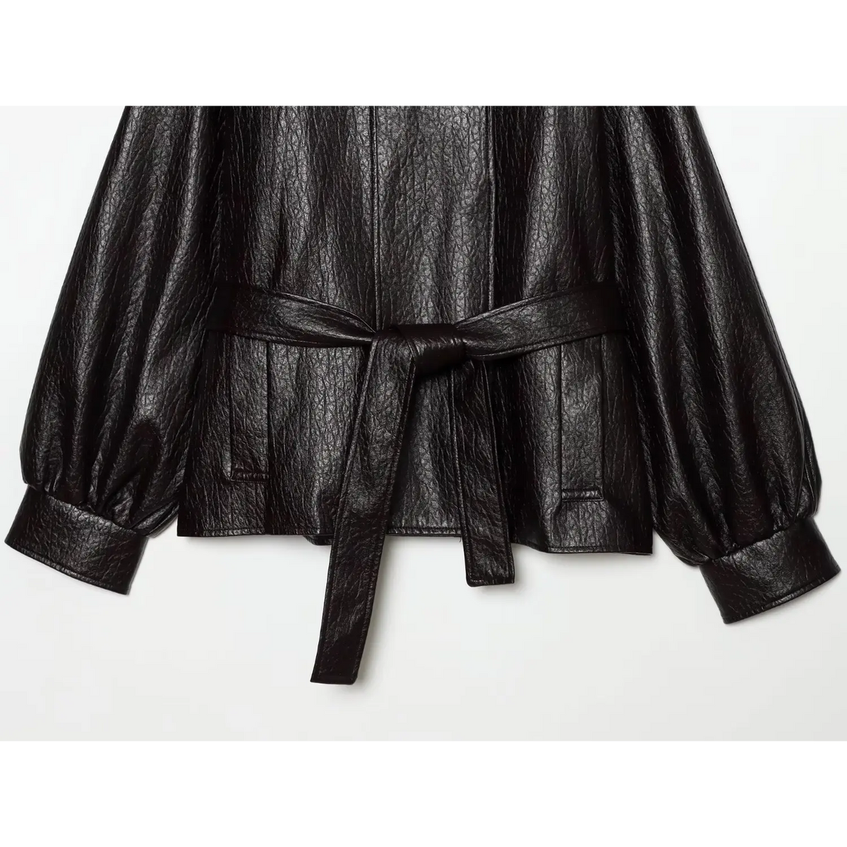Close-up of self tie belt, front pockets and balloon sleeve cuffs on black jacket
