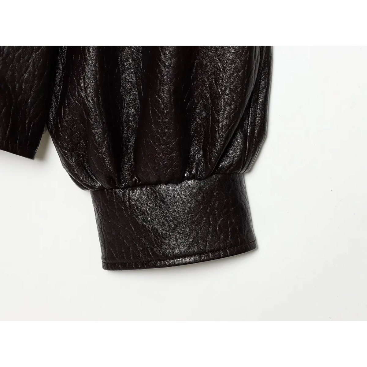 Close-up of straight cuff on black pebbled leather sleeve