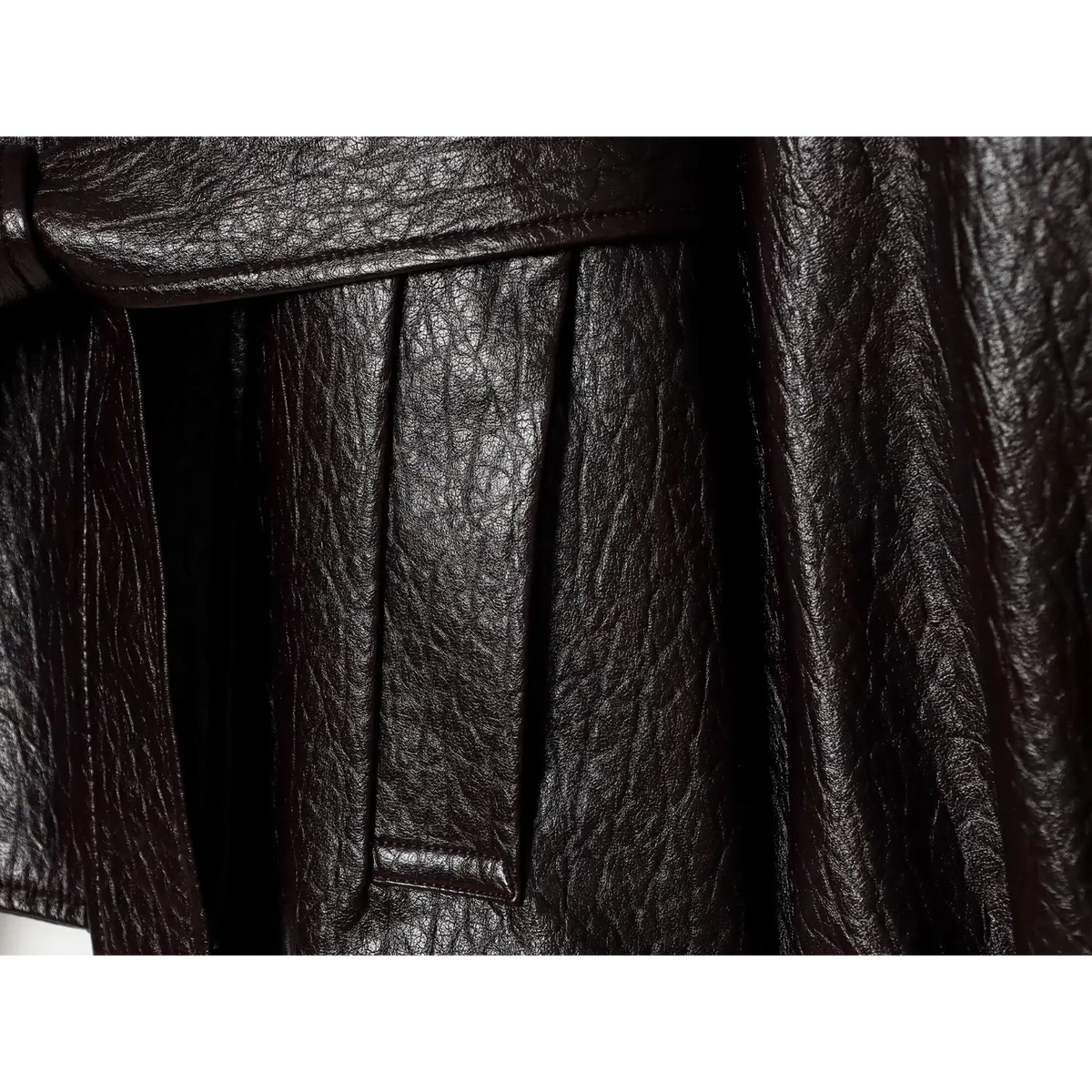 Close-up of welt pocket under leather belt on black jacket