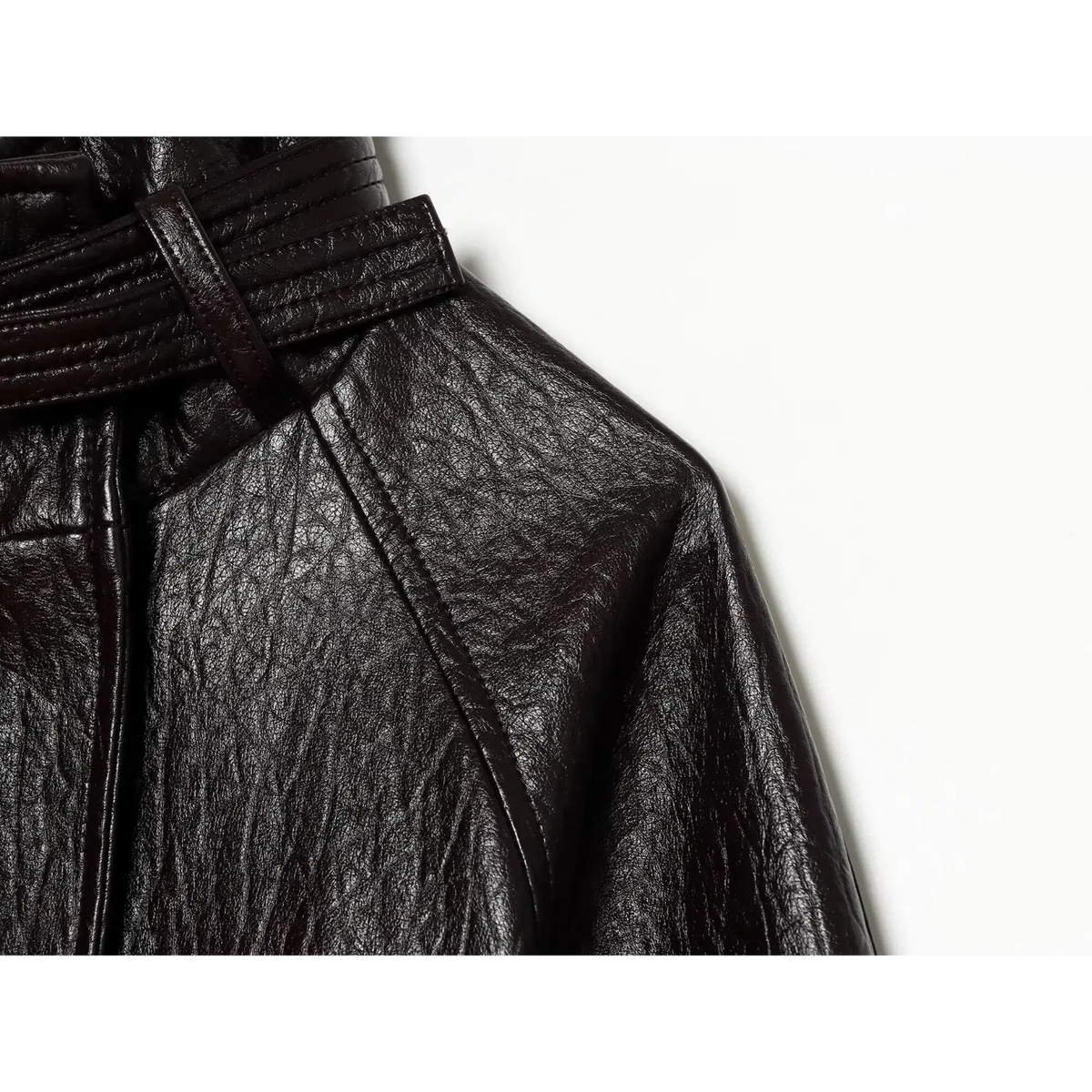 Close-up of raglan shoulder seam on black pebbled leather fabric