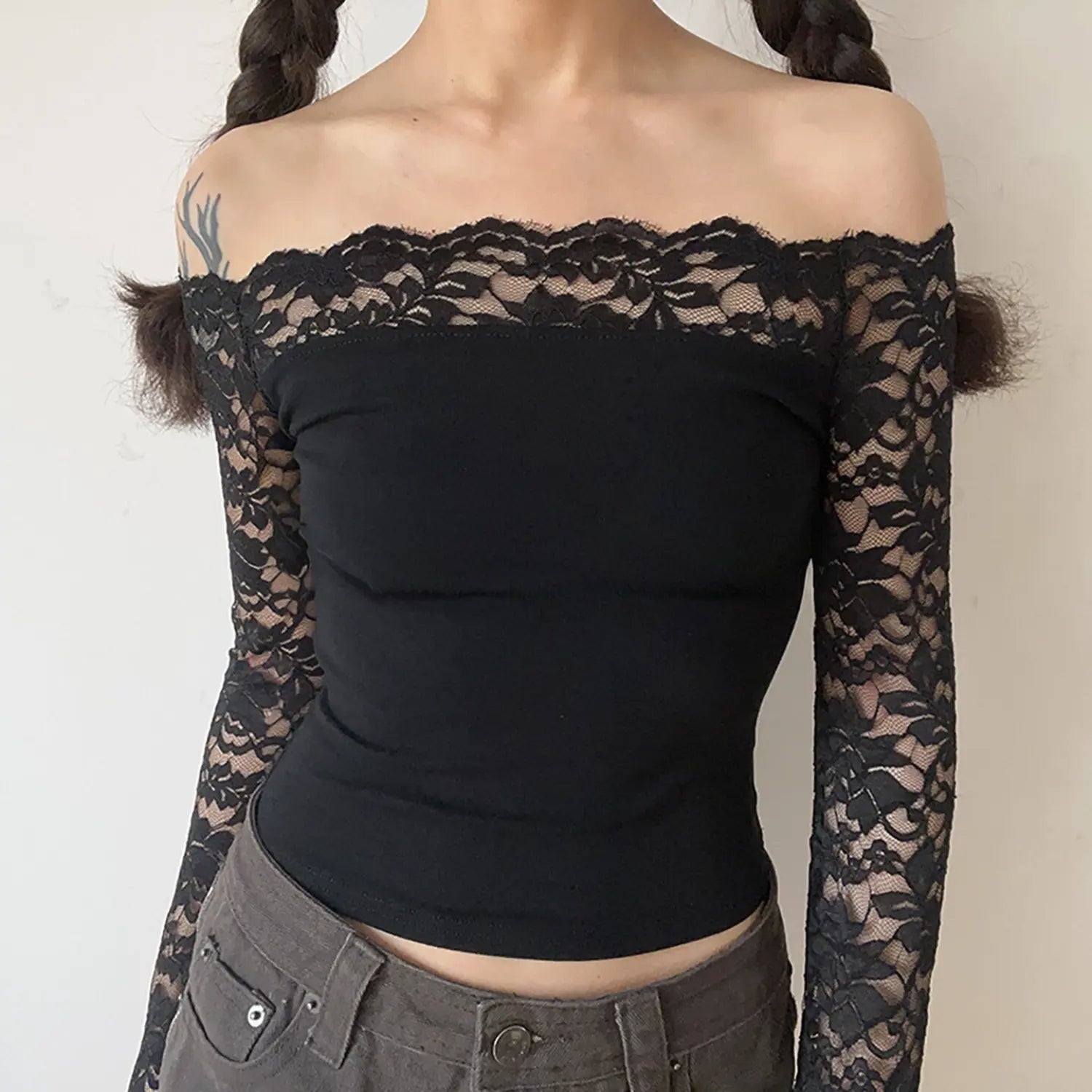 Model front view black off‑the‑shoulder crop top with sheer floral lace long sleeves