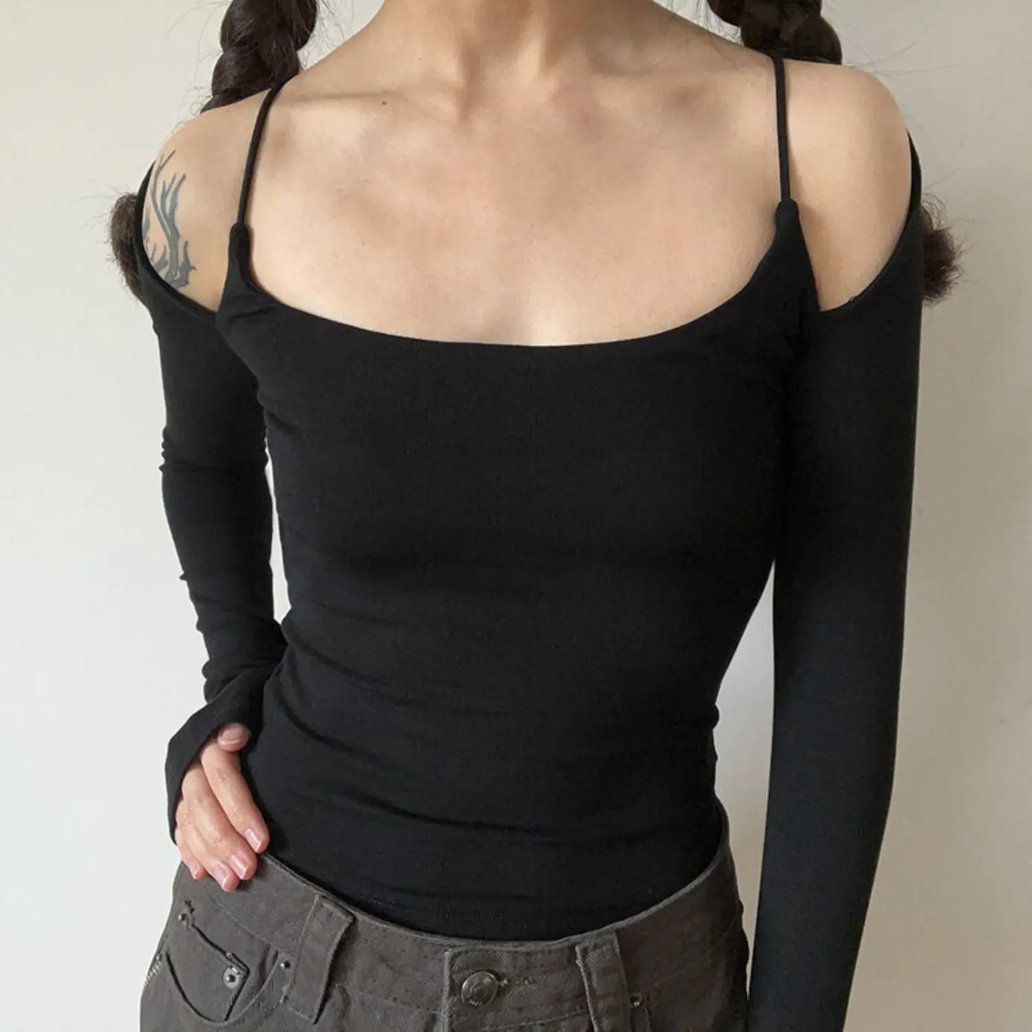 Black spaghetti strap off shoulder long sleeve top half body indoor shot, stretch knit slim cropped fit, matched with denim pants cool hot girl daily layering inner camisole