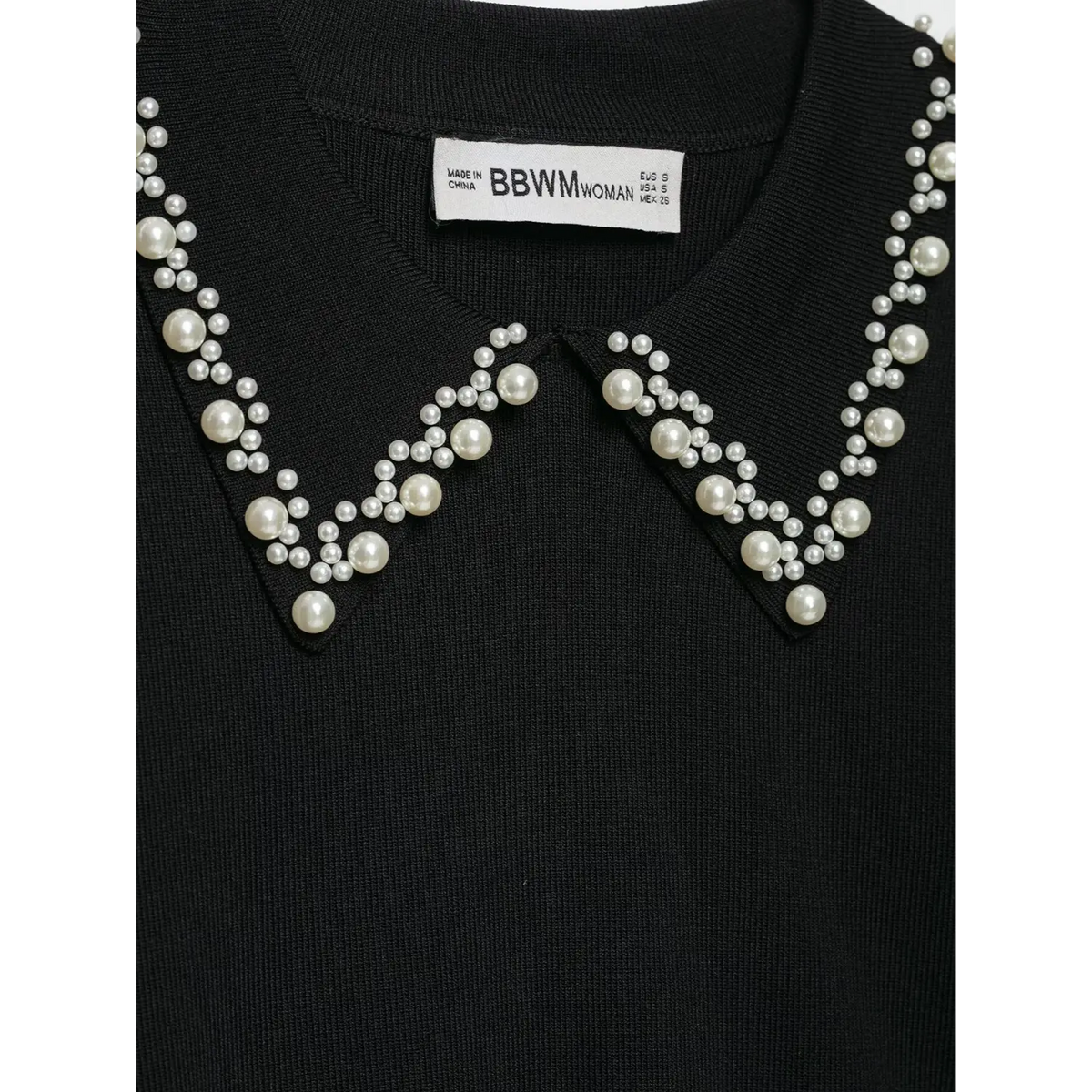 Close-up of collar label and pearl detailing