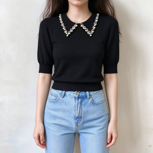 Model wearing black pearl collar knit top with jeans, front view