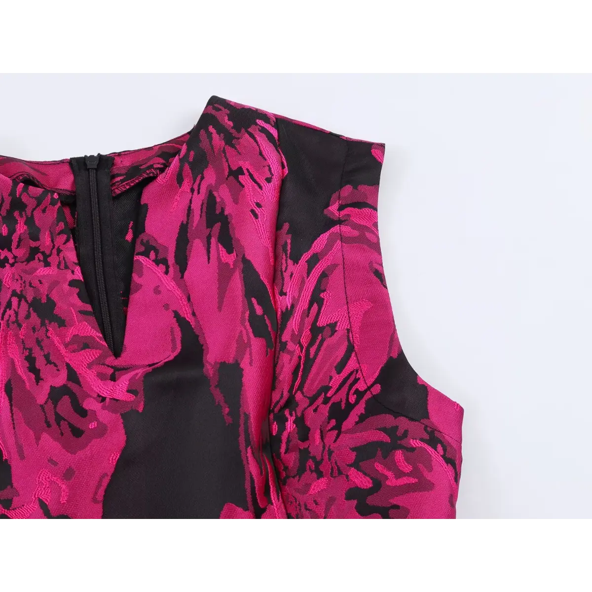 Close-up of the dress shoulder seam, showing the tailored construction and floral jacquard pattern