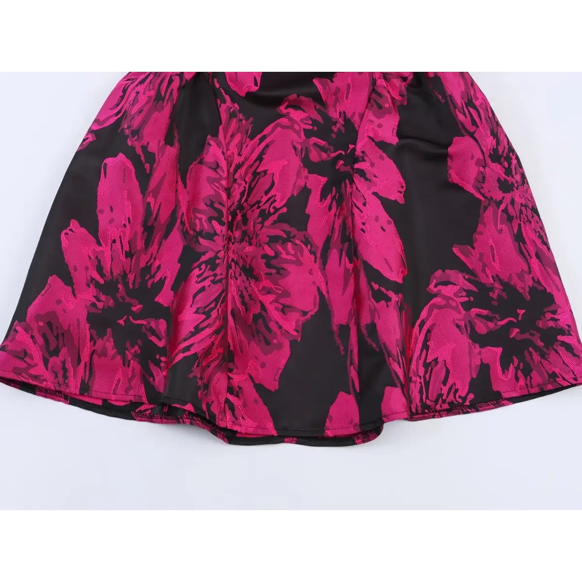 View of the flared skirt hem, showing the full floral jacquard pattern and structured silhouette
