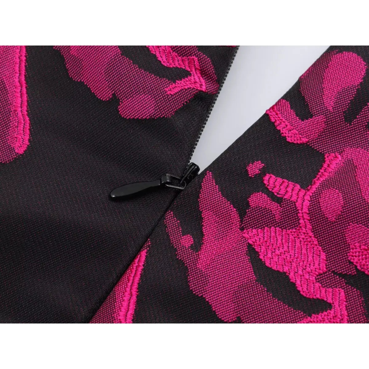 Close-up of the side zipper on the dress, showing the black zipper pull and textured jacquard fabric