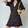 Lifestyle model photo, woman wearing black pink ditsy floral V-neck mini dress