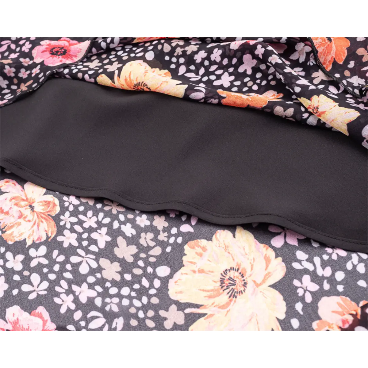Close-up of the layered construction, showing the sheer floral outer fabric and smooth black lining.
