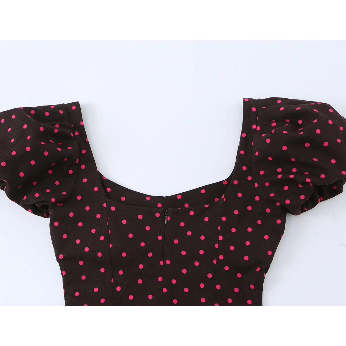 Back view of the dress's neckline, showing the center zipper placement and the full polka dot print.
