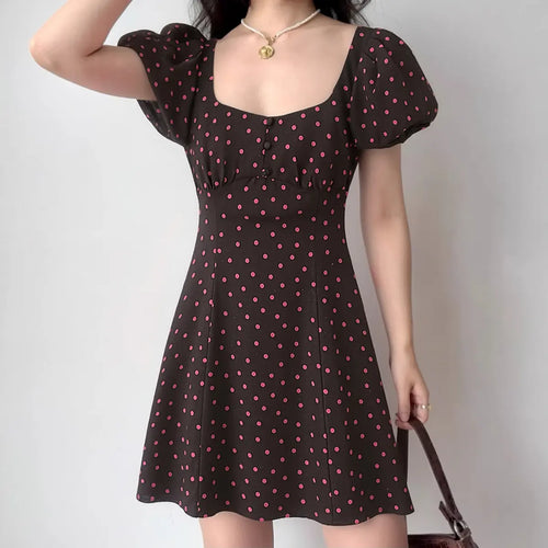 The polka dot dress styled on a model, showcasing its retro-inspired puff sleeves, cinched waist, and playful silhouette.