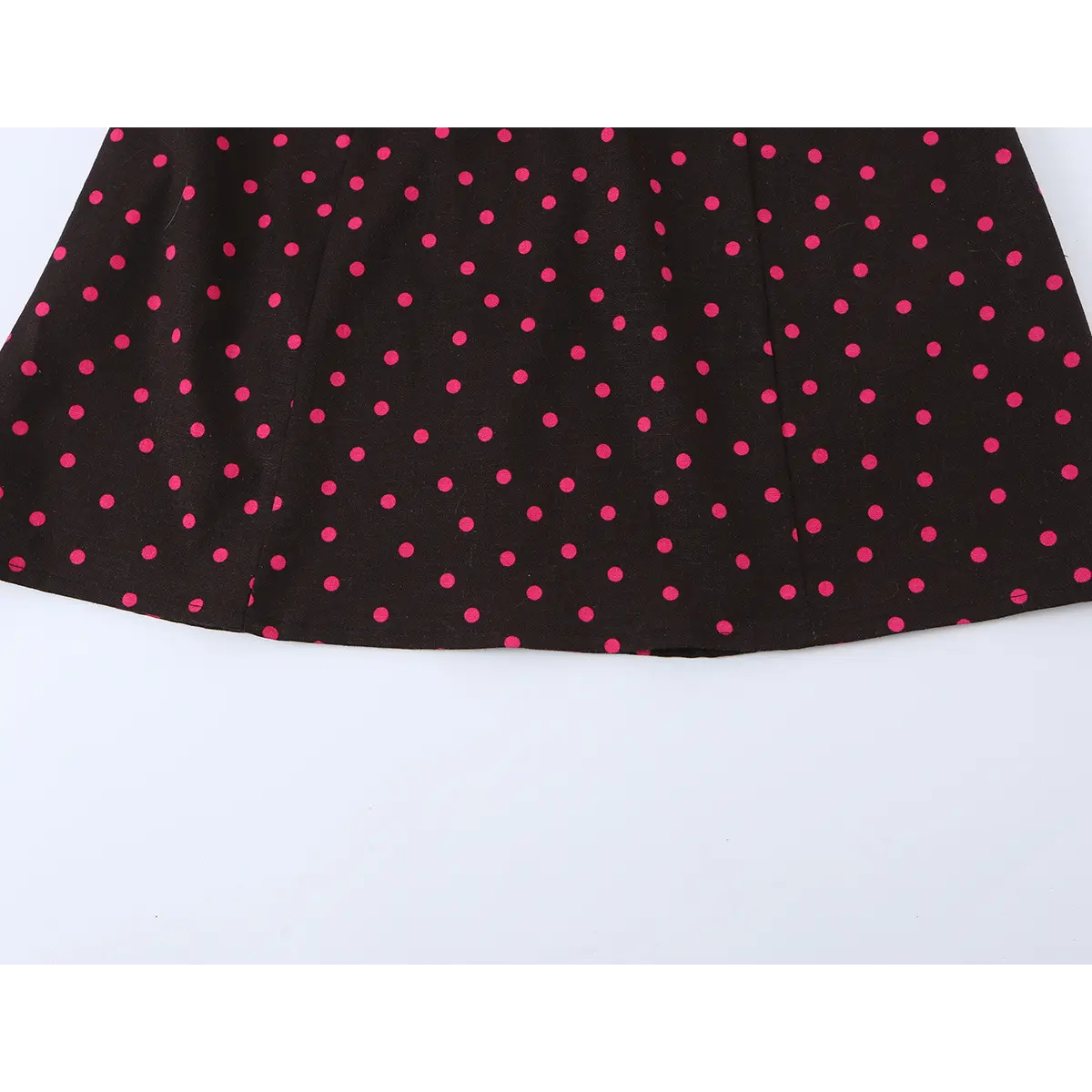 Close-up of the dress's flared skirt hem, showing the clean edge stitching and fabric drape.