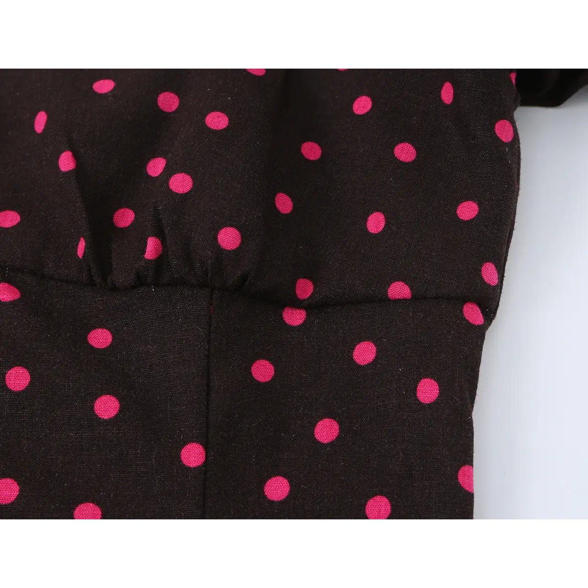 Close-up of the dress's waist seam, showing the gathered transition from the bodice to the skirt.