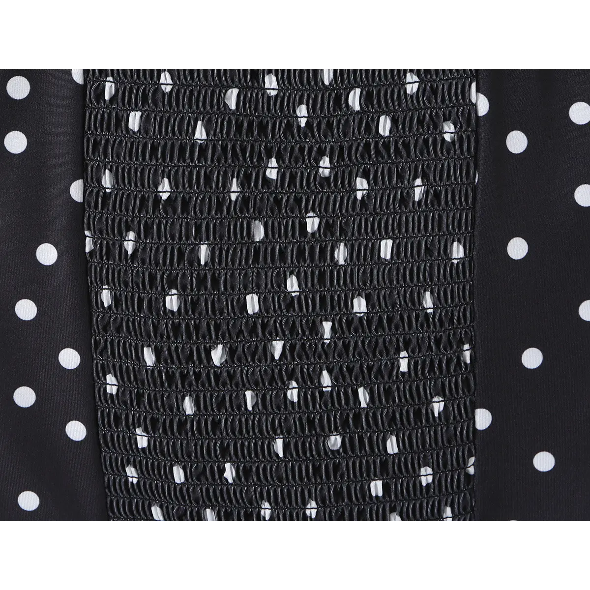 Close-up of the smocked back panel on the black polka dot cami top