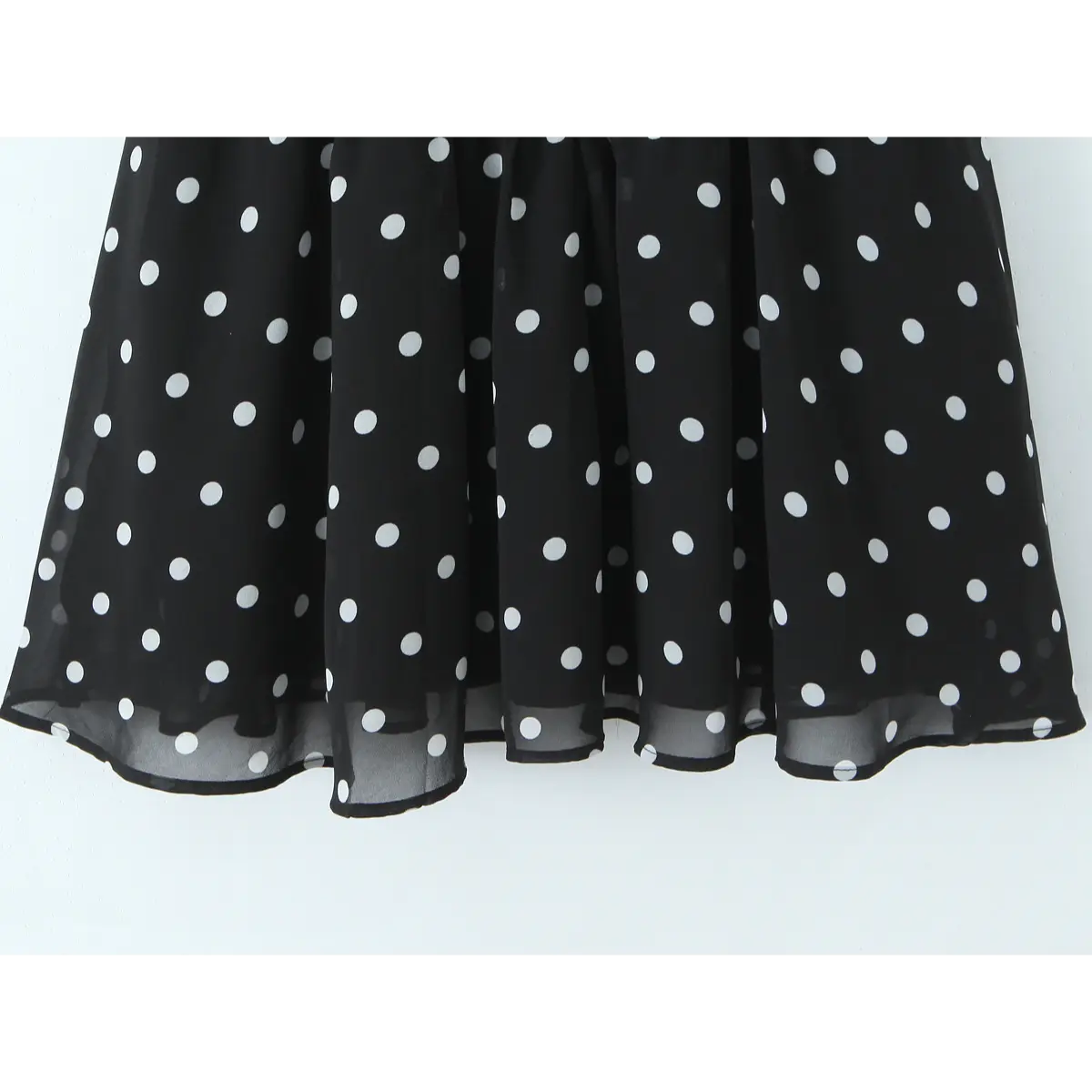 Full view of the flared, tiered chiffon skirt, displaying the black and white polka dot pattern.