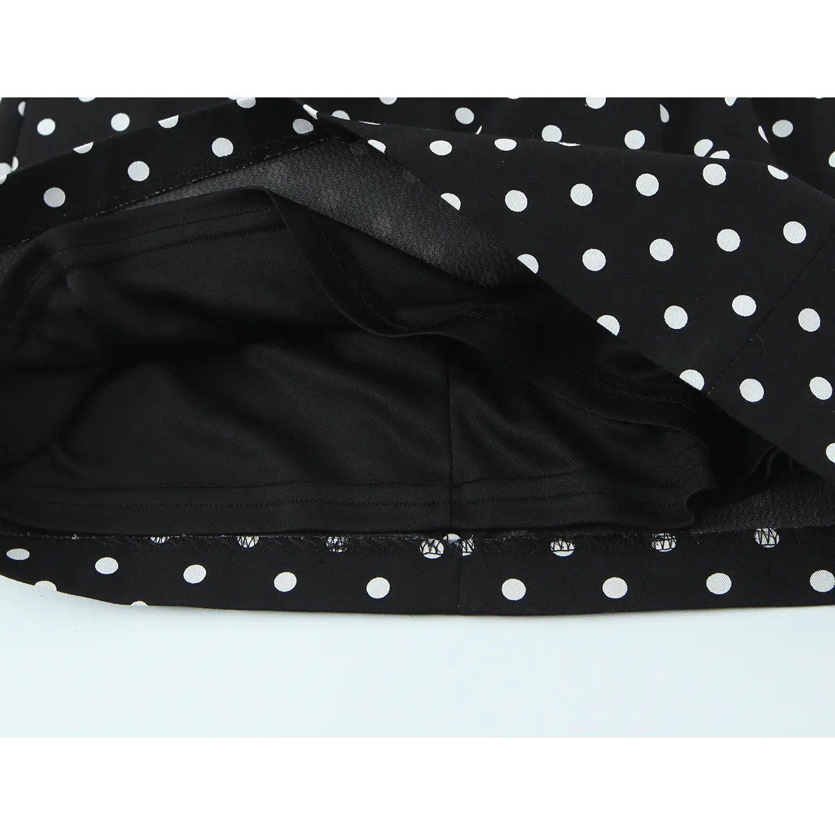 Close-up of the dress's interior, showing the black lining, stitching, and how it attaches to the outer polka dot fabric.