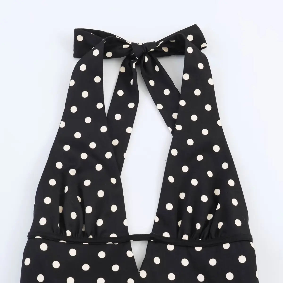 Top view of the halter neckline on black polka dot dress, showing back tie design and open neckline.