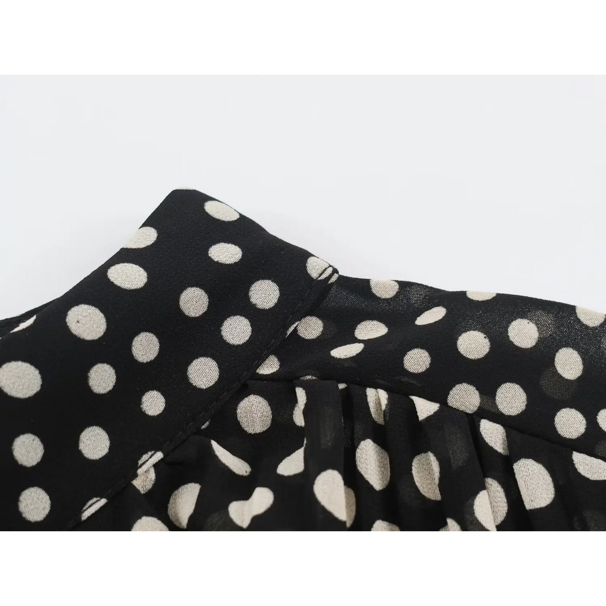 Macro close-up of stand collar fabric texture on black white polka dot maxi dress