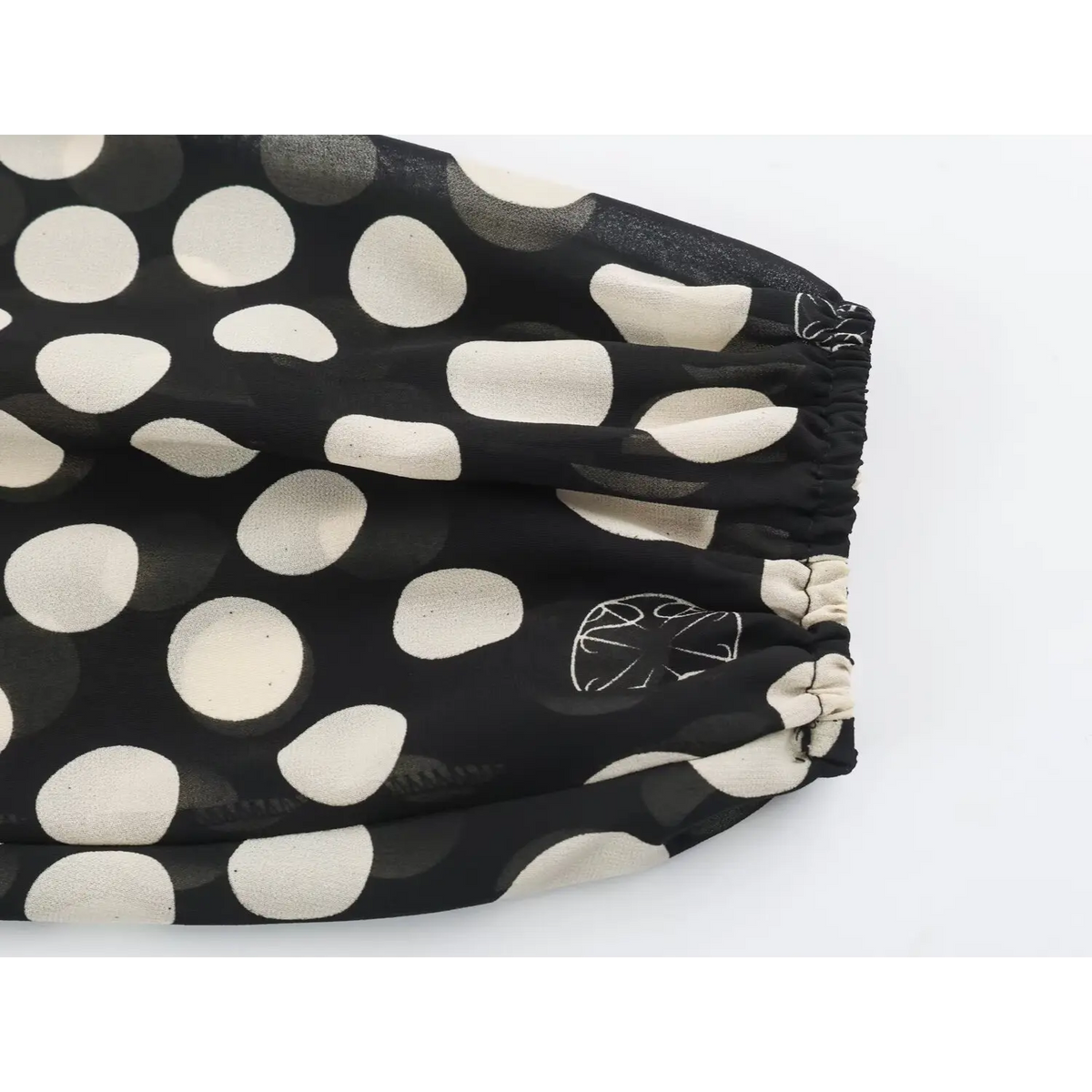 Close-up of elastic balloon sleeve cuff on black polka dot chiffon maxi dress